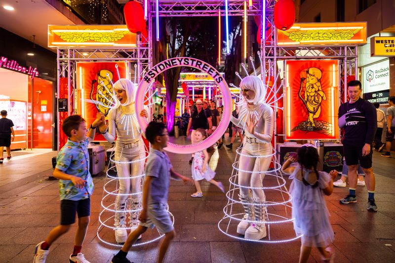 Performers with neon background at Sydney Streets Haymarket Chinatown